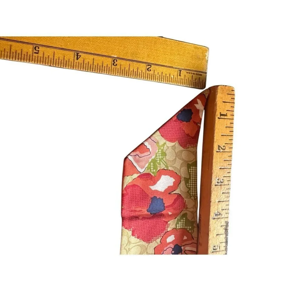 COACH silk twilly scarf orange poppy and tan signature Cs background